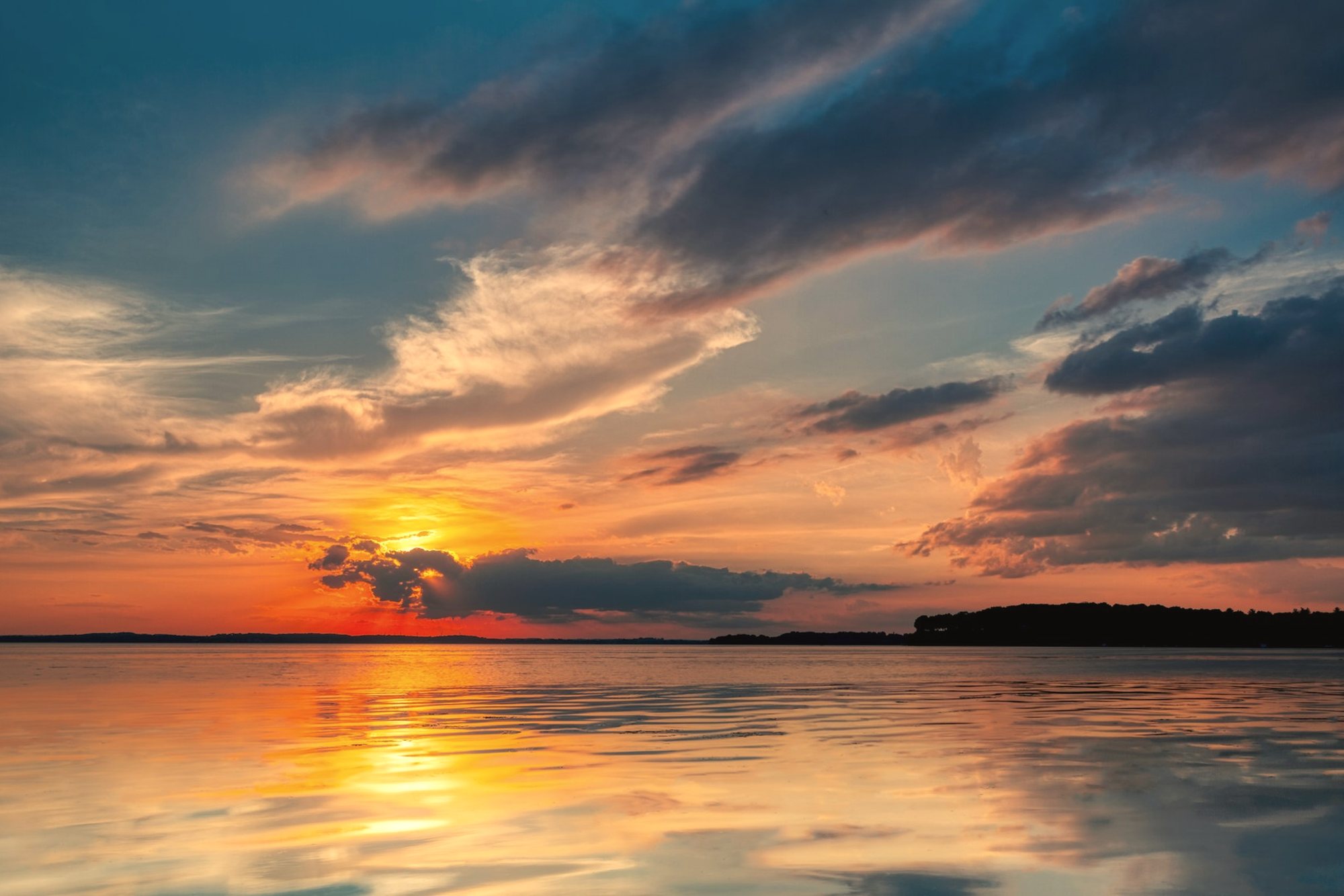 The sun setting over calm water