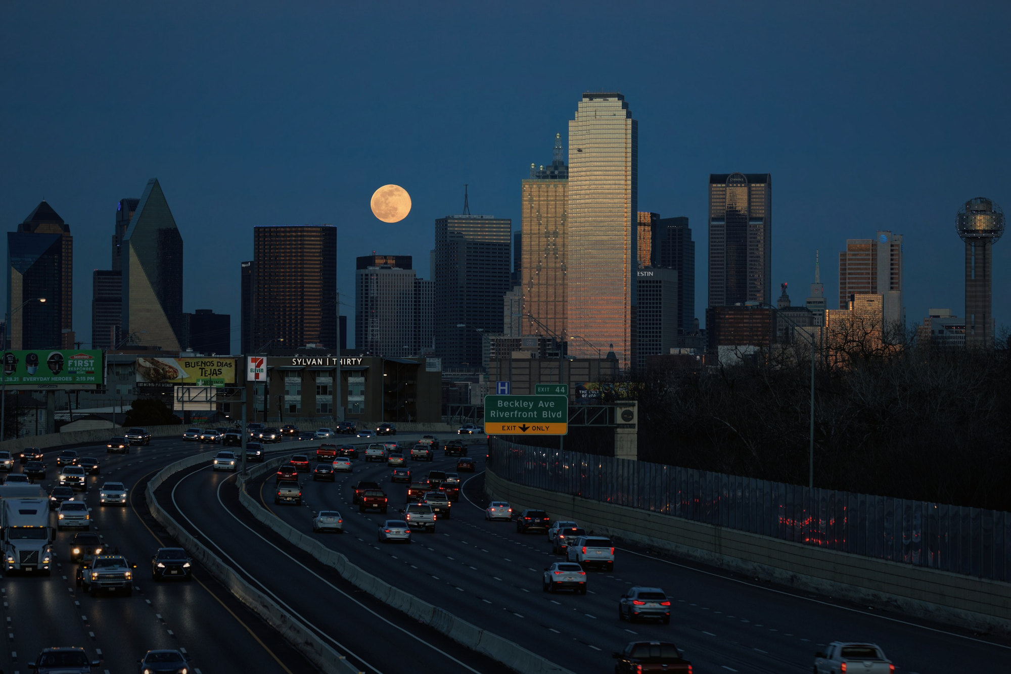 The Dallas skyline at night with the moon rising
